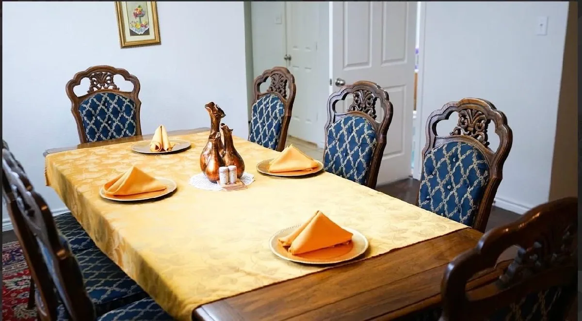 The Heritage Touch dining room, table laid with a gold cloth and orange napkins